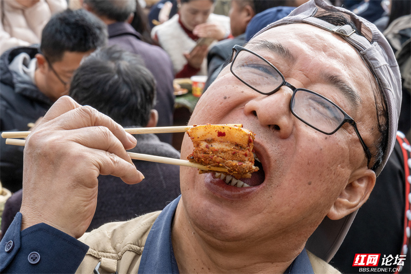 来自山西太原的游客郭先生在千人宴上品尝彝族特色美食“砣砣肉”。.jpg