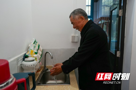 平江县长寿镇宝枫村村民张燕安看着家中的自来水,笑容满面。.marked.jpg 平江县长寿镇宝枫村村民张燕安看着家中的自来水,笑容满面。.marked.jpg