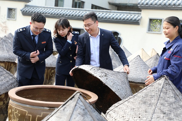 4月12日，国家税务总局湘潭经济技术开发区税务局在龙牌食品股份有限公司开展“送政策解难题优服务”助企纾困行动，图为税务工作人员与龙牌酱油工作人员一同在晾晒场，查看酿制酱油、了解企业生产经营情况，为老字号企业纾困解难。.jpg