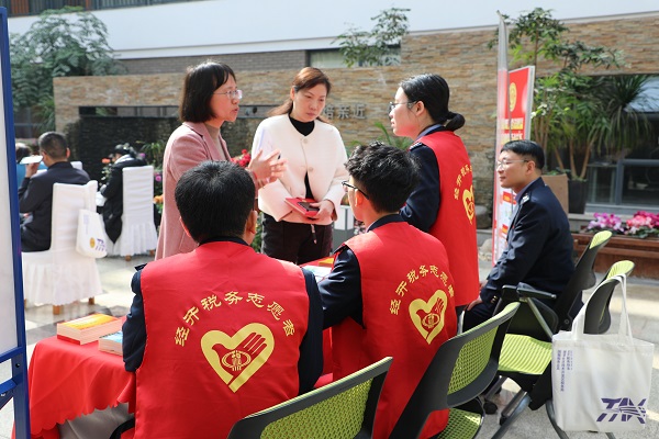 3月31日，身着“志愿红”的湘潭经开区税务局的德·星光志愿服务队在“税费皆重提质效 精诚共治向未来”主题活动暨第32个税收宣传月启动仪式的现场“出摊”，为与会的辖区企业、新业态从业者发放宣传手册，面对面提供纳税咨询，手把手辅导操作APP。3.jpg