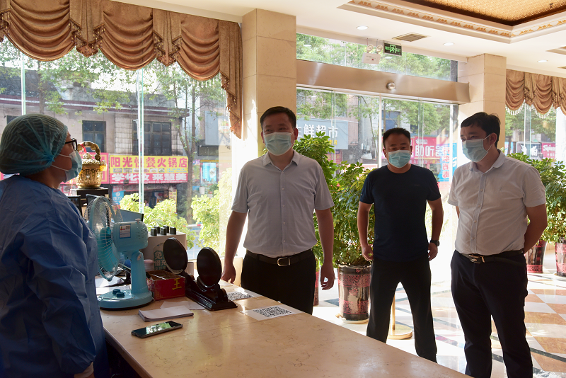 图为永顺县委书记彭军(左二)与集中隔离点医护人员进行交谈.