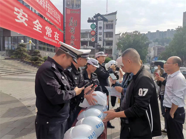 文明新风润湘西丨凤凰公安交警开展“一盔一带”交通安全宣传送头盔活动