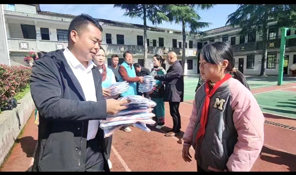 凤凰县教体局领导与志愿者一起为孩子们发放新校服。.jpg