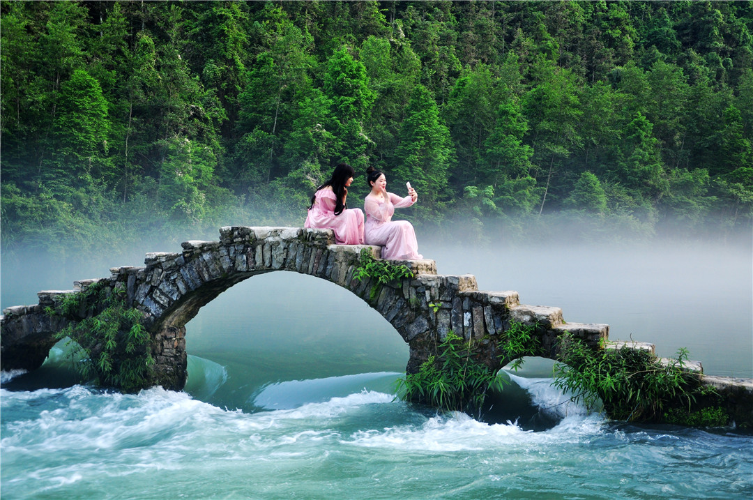 “网红桥”地处凤凰至长潭岗风景区的路边上，距县城十余公里。是一座古石拱桥连一排跳岩横卧沱江上游浅滩河面上。