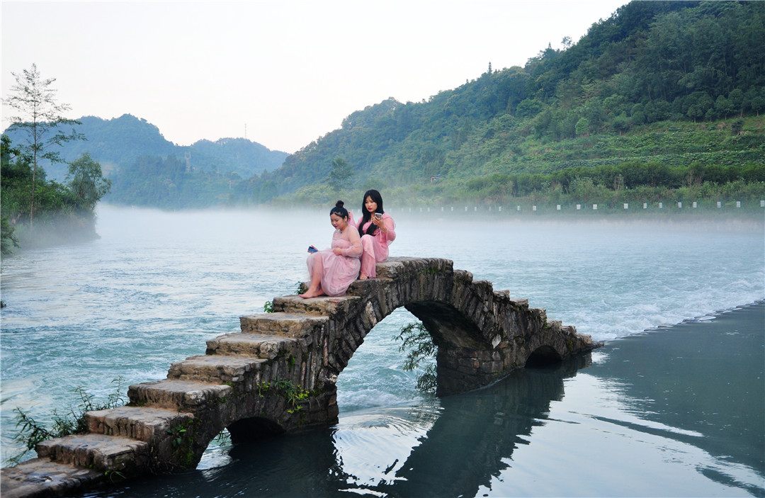 5月31日傍晚，凤凰县长潭岗景区“网红桥”，游人赏景游玩、拍照发圈、录拍抖音，不亦乐乎。近日，久雨初晴，长潭岗景区景美如画，“网红桥”成为当地人和外地游客的网红打卡地。
