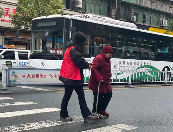 1、志愿者正在搀扶老人过马路.jpg