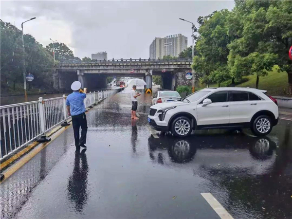 道路被淹，莲乡交警雨中指挥来往车辆绕行.jpg