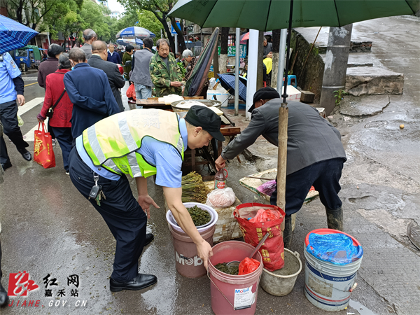 珠泉执法人员帮占道经营的摊贩收拾摊位.jpg