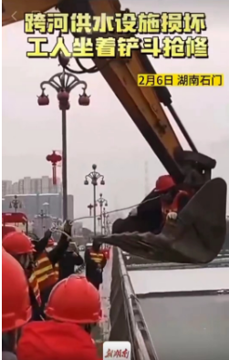 跨河供水设施损坏工人坐着铲斗抢修