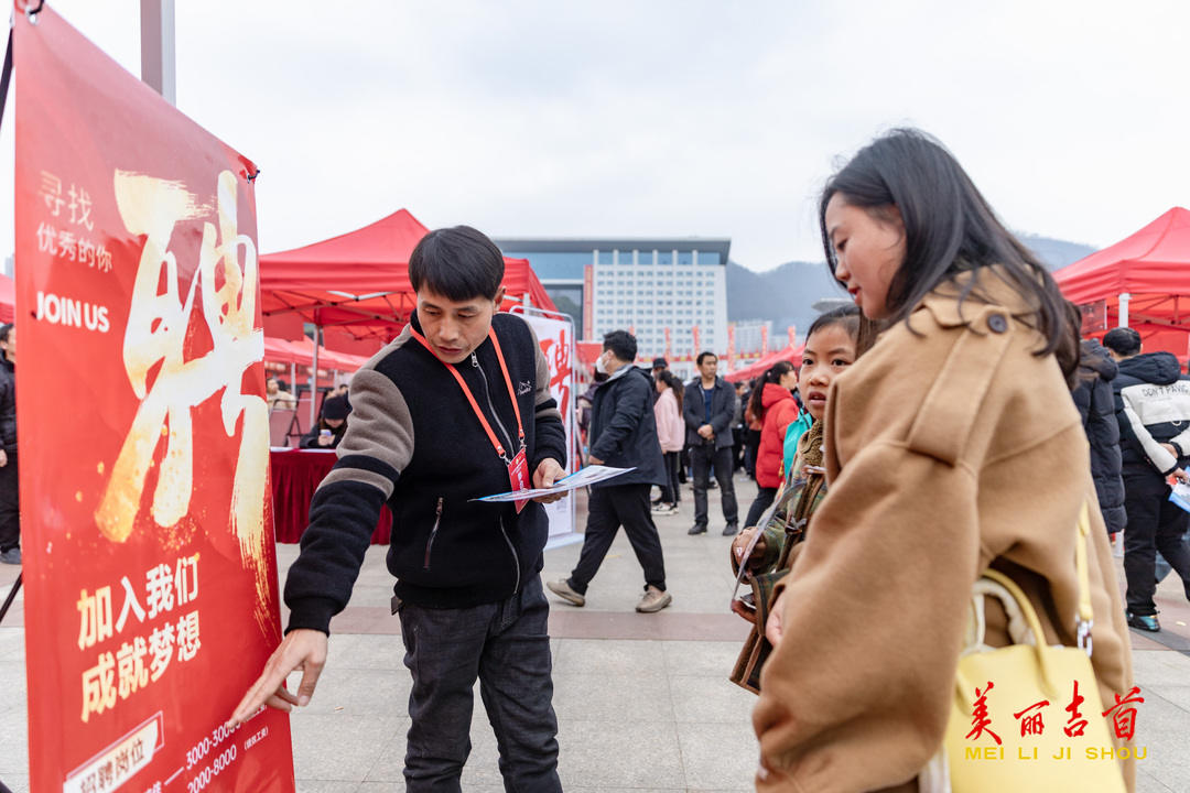 吉首市人民广场，招聘工作人员在为求职者介绍招工信息