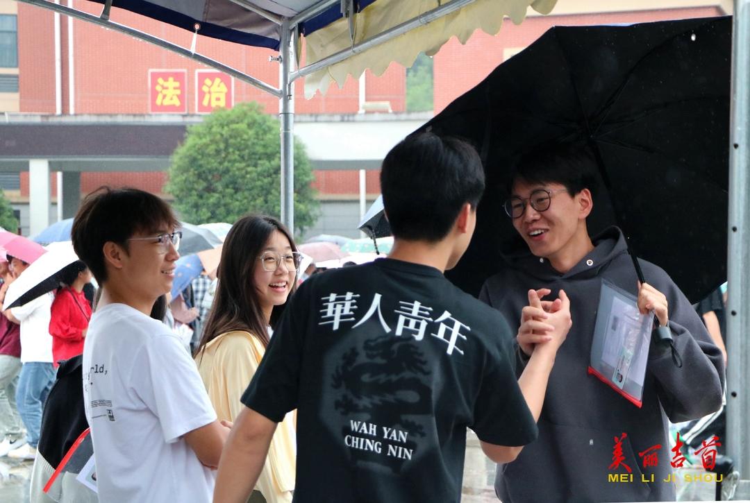 6月8日上午，两位考生在考试结束后击掌互贺，微笑感染着避雨的同学。