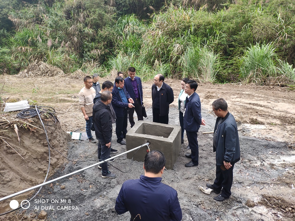 娄底市公路建设养护中心乡村驻村工作队与斗笠山镇专职副书记梁洪辉一起察看水井建设进度.jpg