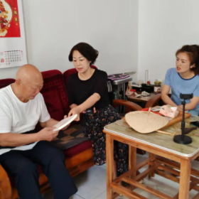 为居民区老党员送书，宣传党的好政策