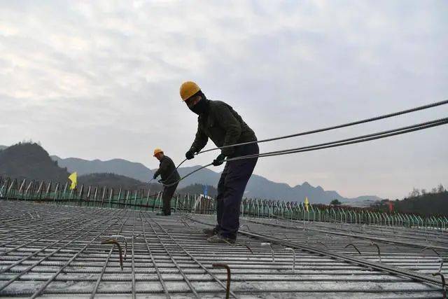 工人在湖南省湘西土家族苗族自治州湘西机场高速路建设工地施工。当日是新年第一天，众多劳动者坚守岗位，在忙碌中度过元旦。（龙恩泽 摄）