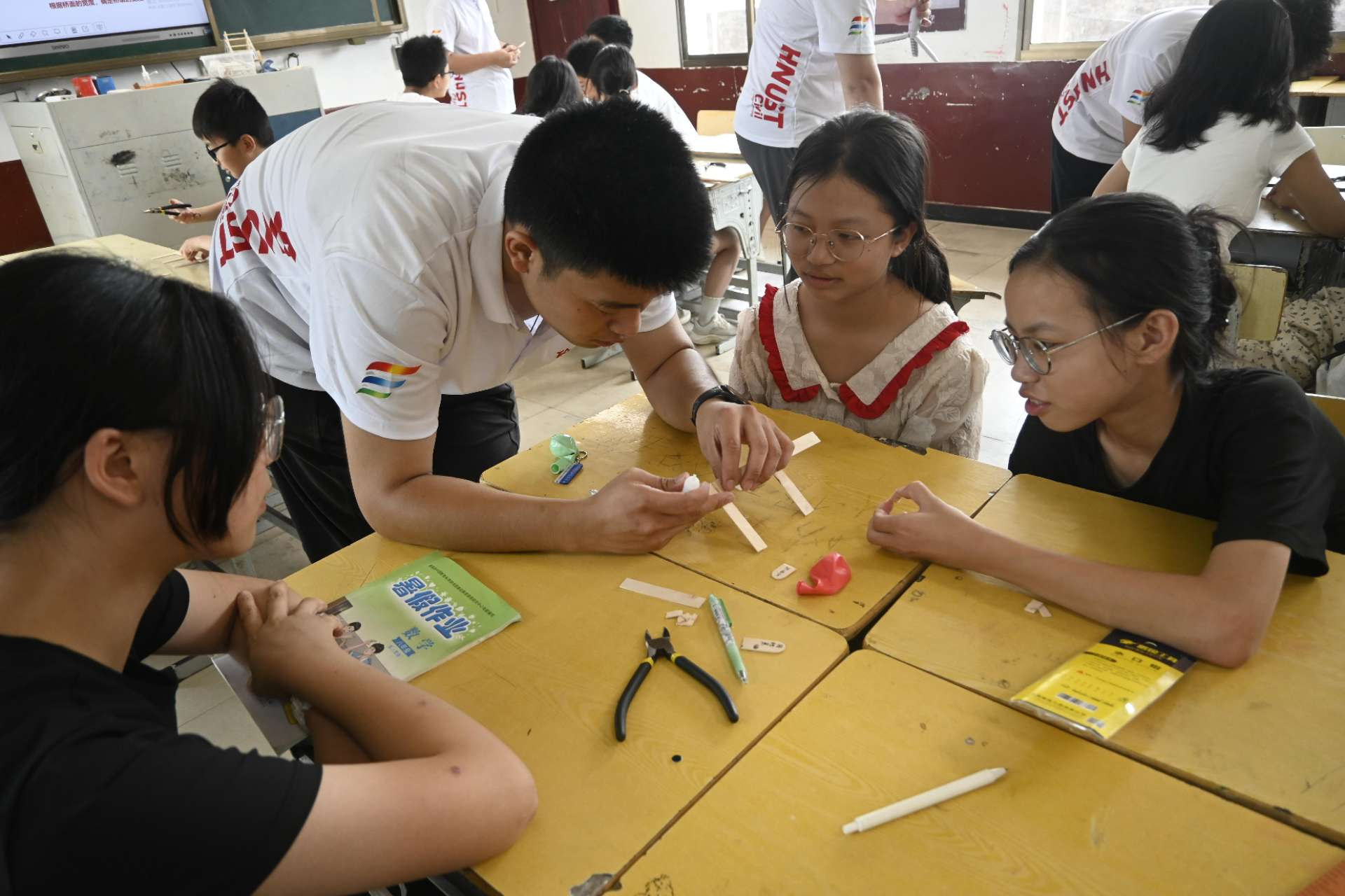 志愿者指导学生动手实践.png 志愿者指导学生动手实践.png