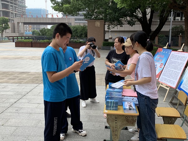 工作人员给同学们发禁毒宣传册.jpg