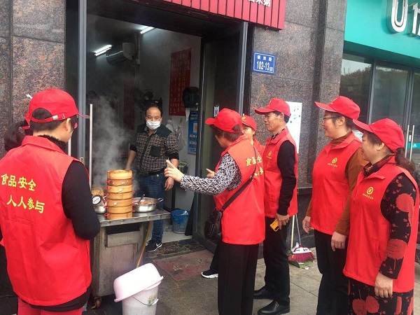 2社区志愿者向沿街餐饮单位食品门店单位讲解食品安全的有关法律法规，监督食品门店、摊贩等正确履行食品安全法，做良心食品。.JPG