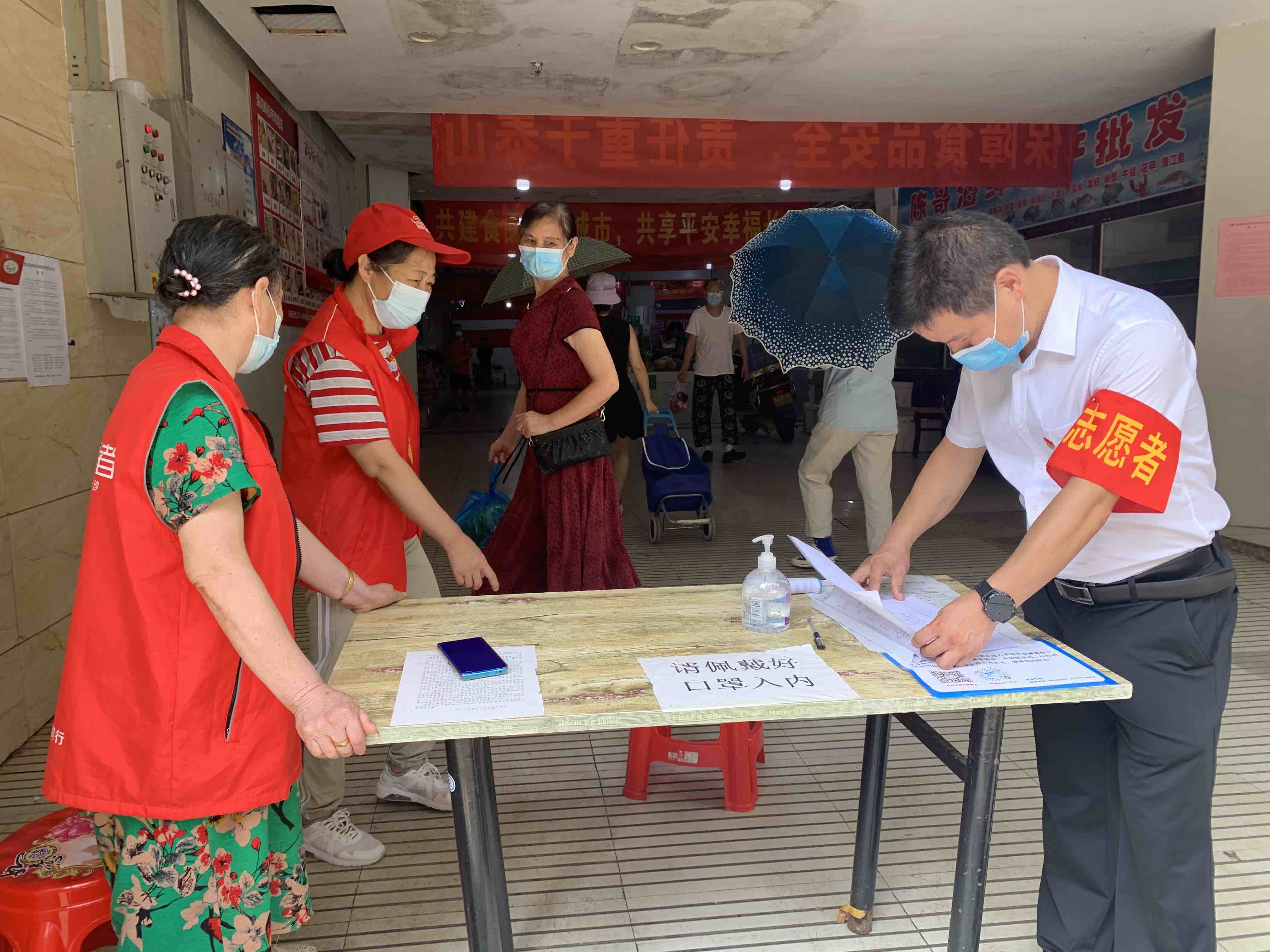志愿者在农贸市场进行来访登记.jpg 志愿者在农贸市场进行来访登记.jpg