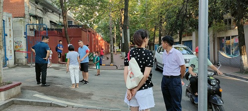 志愿者在望月湖第二小学门口引导报到的学生和学生家长.jpg