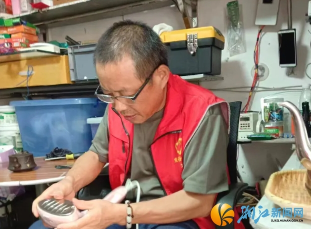 刘正义正在帮居民维修电器。