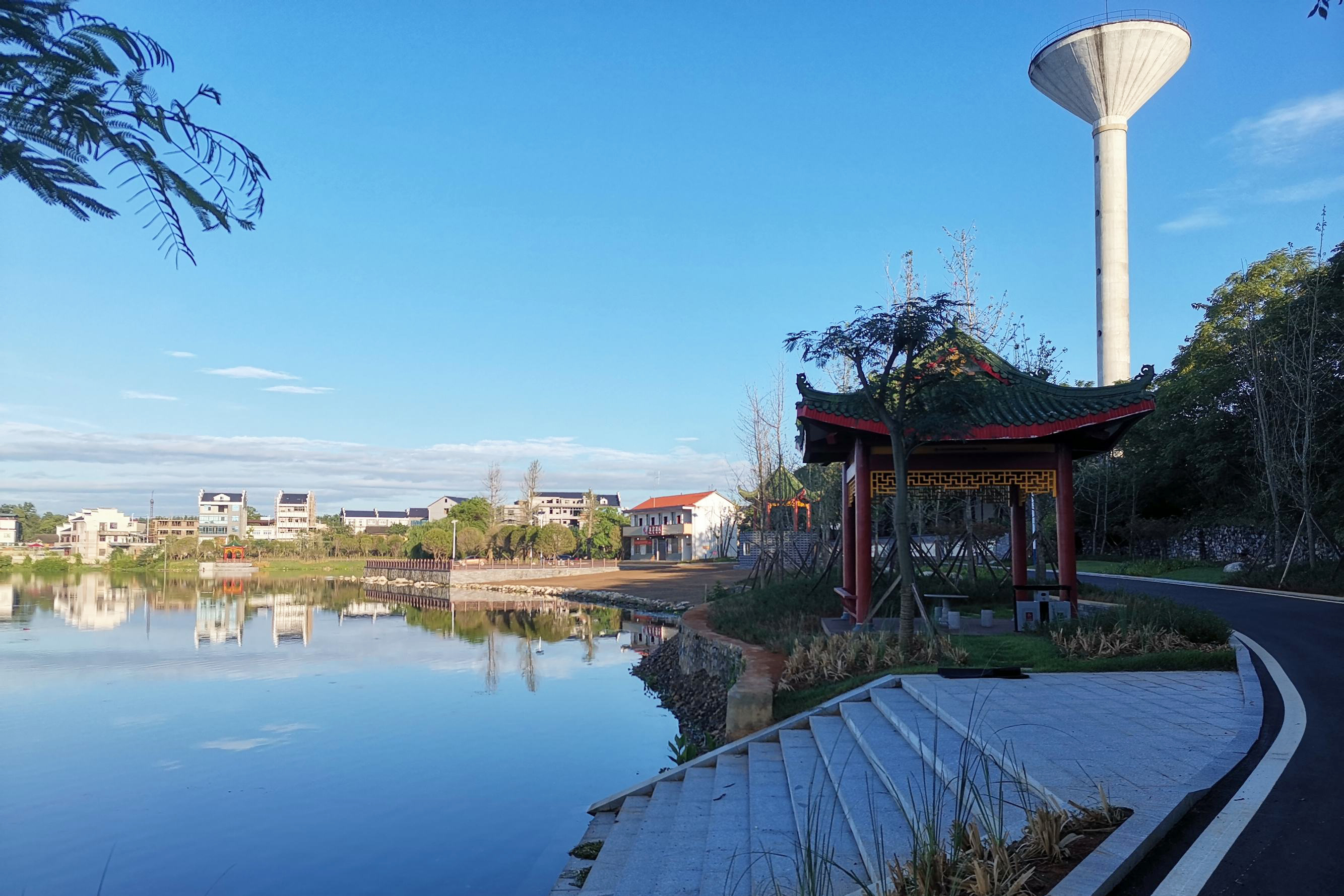晨光熹微风轻轻，天蓝如洗云悠悠。凉爽的风轻拂脸颊，干净整洁的永富大道两旁，有序停靠着赶早的大小车辆；人民桥下碧波闪耀，水面上散满了碎银似的波光潋滟。这里就是离零陵古城只有十多分钟车程的富家桥镇永富社区。