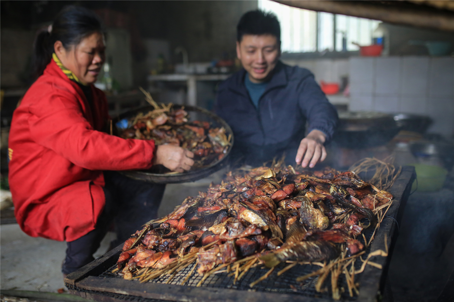 零陵区大庆坪乡下河塘村，工作人员在脱贫户唐翠英家收购干鱼块。潘爱民摄