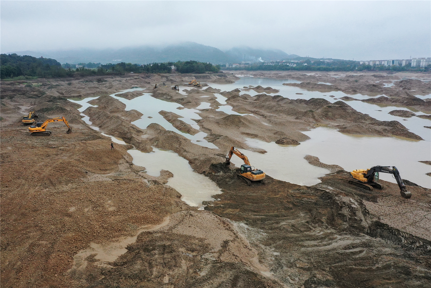 零陵区凼底乡油山岭村，机械设备在平整潇水河弃置采砂尾堆。