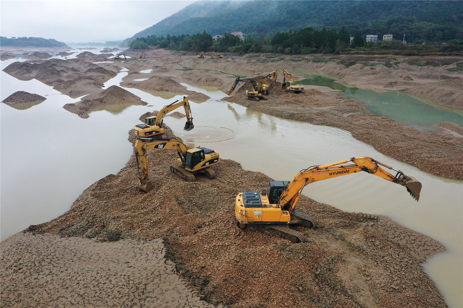 零陵区凼底乡油山岭村，机械设备在平整潇水河弃置采砂尾堆。