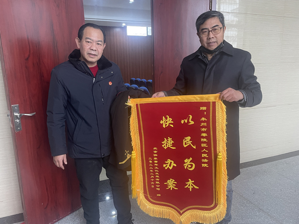 签署协议当天，原告将一面锦旗赠送给康明正(小图）.jpg