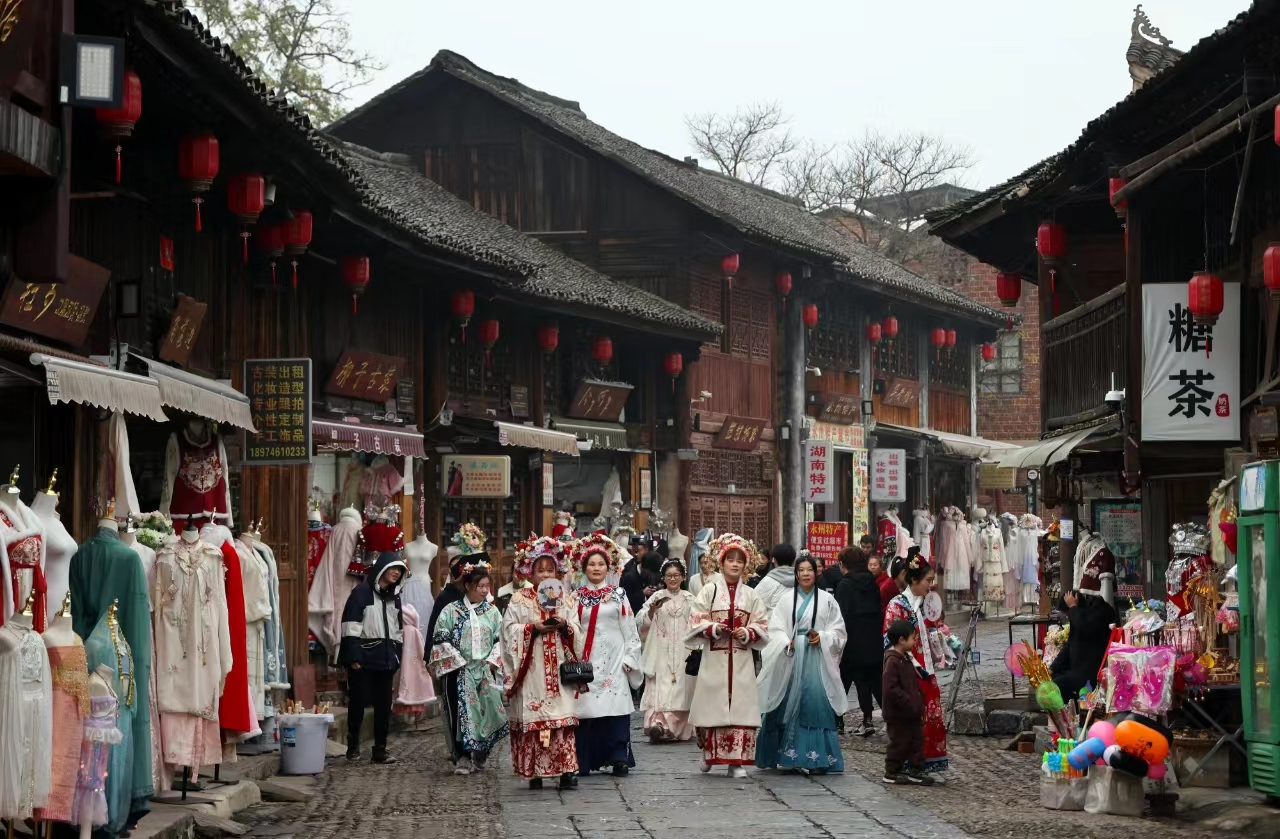 “欢迎大家来到零陵古城！”1月16日，柳子古街熙熙攘攘，好不热闹，柳宗元、怀素、蒋琬等永州名人的扮演者在柳子庙前齐跳“科目三”迎客，让游客体验古装穿越乐趣。（陶旭日 摄）
