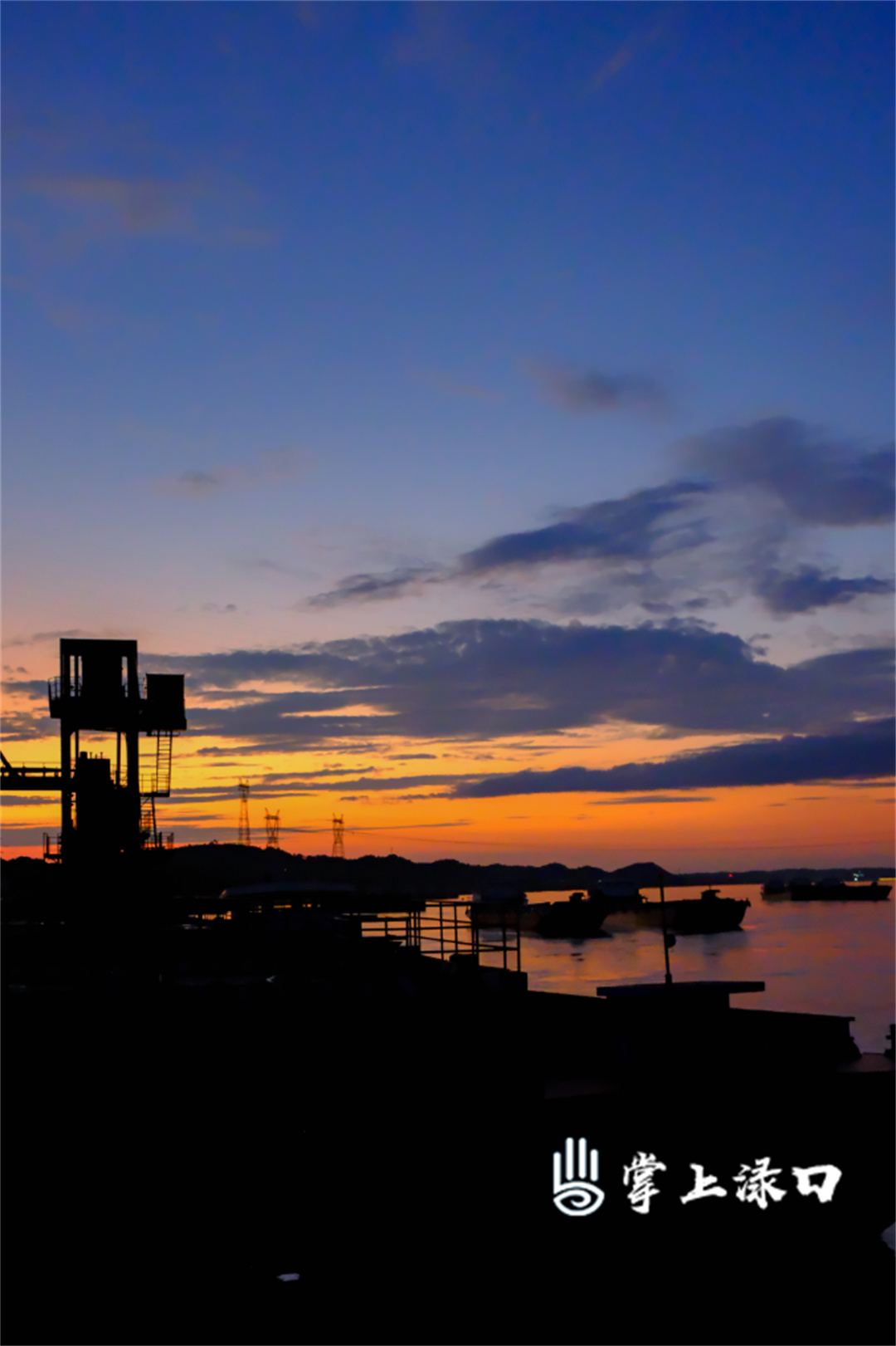 【图片：姜颖悦  文字：刘慧】
静谧的湘江码头，夕阳慷慨地泼洒金红颜料，华新水泥的钢铁骨骼在霞光中刻下剪影，将这里与粼粼波光调和成一首壮丽的工业诗篇。