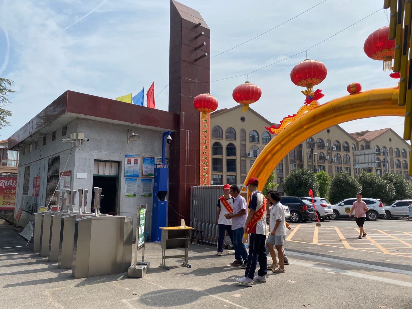 校门口，家长和新生在志愿者的引导下进行健康码扫码，体温检测。