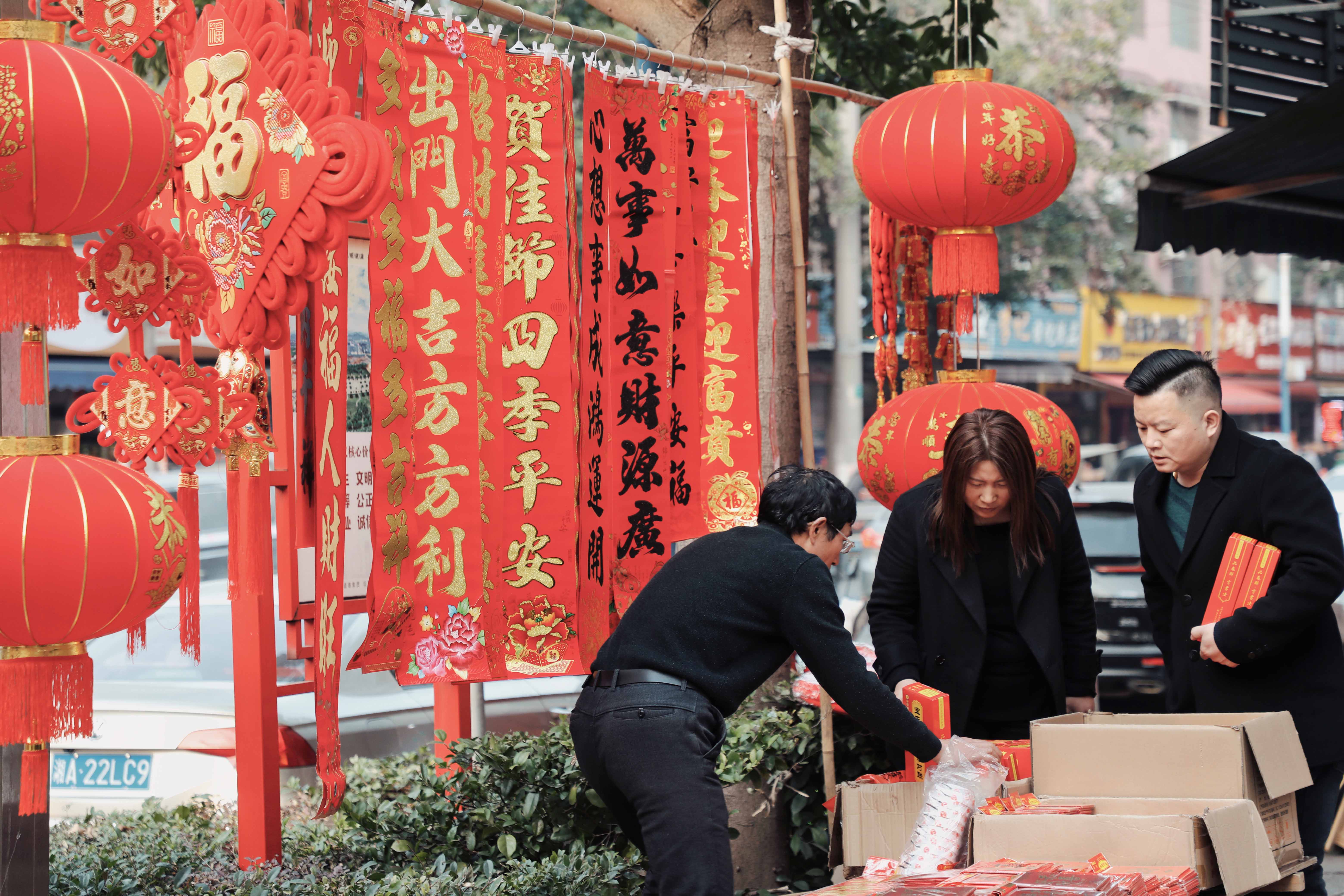 在娄星区涟滨街老街市民们穿梭在摊位之间，精心挑选着心仪的春联，大家手中拿着一幅幅红彤彤的春联，脸上洋溢着幸福的笑容。